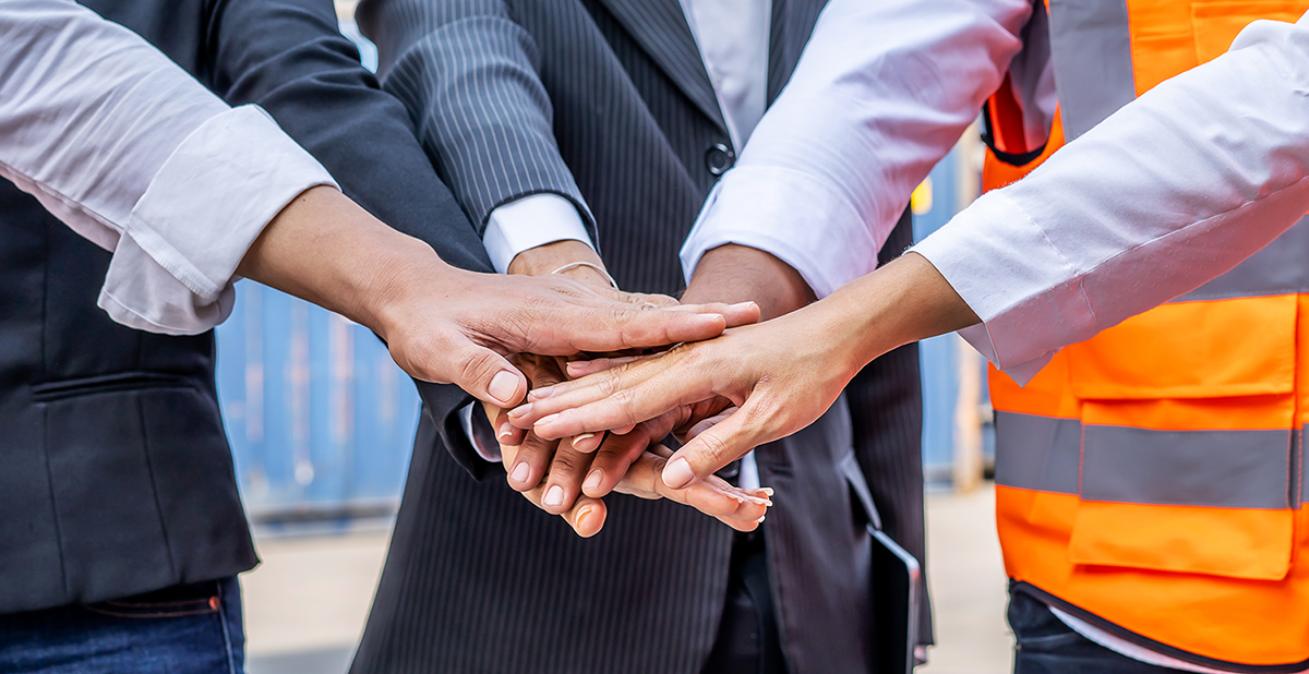Group of employees and management team wearing logistic uniforms for exporting products abroad, stand to put your hands up and raise your hands together for a harmonious work experience
